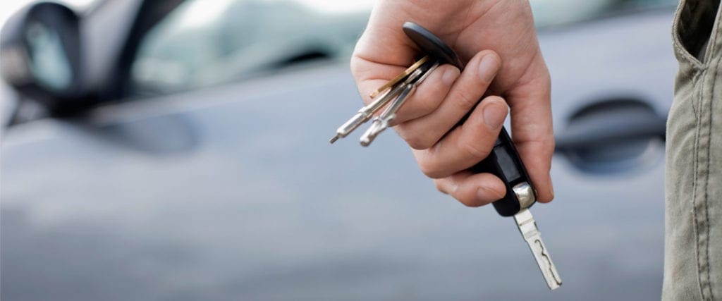 A hand holding car keys with a blurred car in the background, perhaps ready to unlock or start the vehicle—highlighting the importance of awareness around DUI regulations, especially in light of recent discussions by the Senate Public Safety Committee. CA Norml