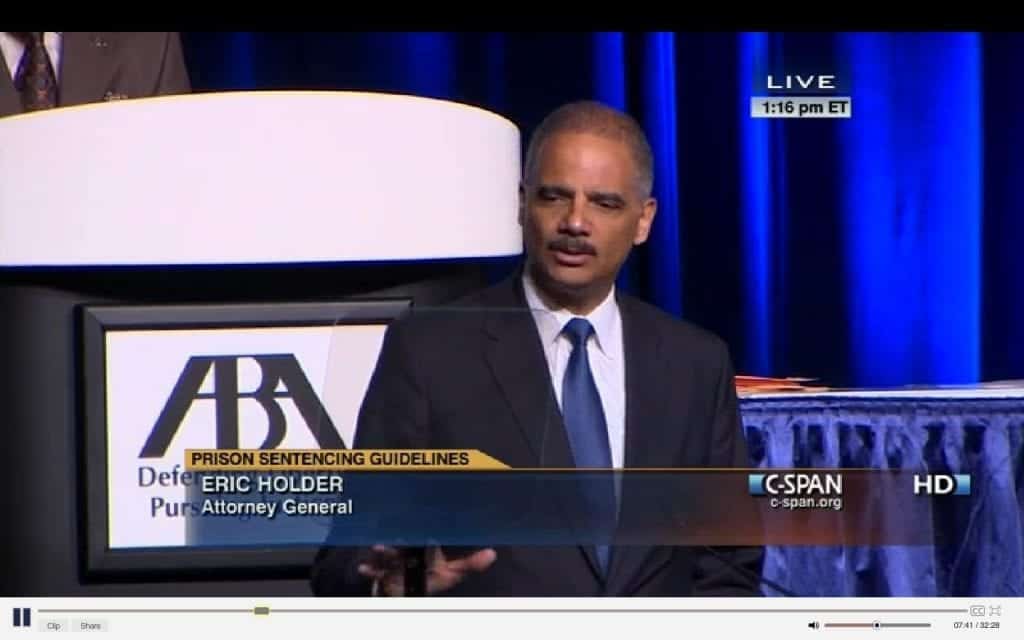 Attorney General Eric Holder speaks at a podium with "Prison Sentencing Guidelines" displayed, addressing the SF ABA Meeting. The event, broadcast live on C-SPAN with an ABA logo in the background, focuses on mandatory minimum drug-crime sentences. "1:16 pm ET" is shown at the top right corner. CA Norml