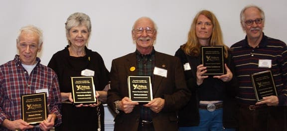 Five people stand in a row, each holding a plaque. They are smiling and appear to be at the Conference of the Century in San Francisco. Four of them wear name tags on their chests. The background is a plain, white wall. CA Norml