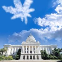 Image of a large white government building with a dome, set against a blue sky. A cloud shaped like a marijuana leaf is prominent in the sky above the building. The bottom text reads "California NORML" and "www.CaNORML.org". This symbolizes California's evolving marijuana regulation. CA Norml