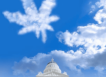 A tall white government building with a domed roof stands against a vibrant blue sky. The sky, dotted with fluffy clouds, including one shaped like a maple leaf, sets the perfect backdrop for Lobby Day. CA Norml