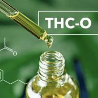 A dropper with yellow liquid is held over an open bottle labeled "THC-O Acetate" with a chemical structure in the background. The image, featuring a green leafy backdrop, suggests a natural or plant-based product. CA Norml