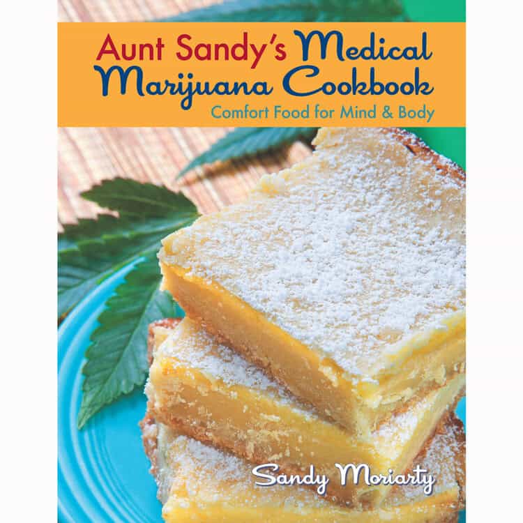 The cover of "Aunt Sandy's Medical Marijuana Cookbook" by cannabis cultivation expert Sandy Moriarty features lemon bars dusted with powdered sugar on a plate with a cannabis leaf underneath. The subtitle reads: "Comfort Food for Mind & Body." Endorsed by Ed Rosenthal, this book includes growing tips. CA Norml