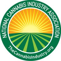 Logo of the National Cannabis Industry Association featuring a circular design with green borders, a yellow and green sunburst background inside the circle, and the organization's name and website "TheCannabisIndustry.org" written around the edge. This logo symbolizes deep roots in building special partnerships within the cannabis industry. CA Norml