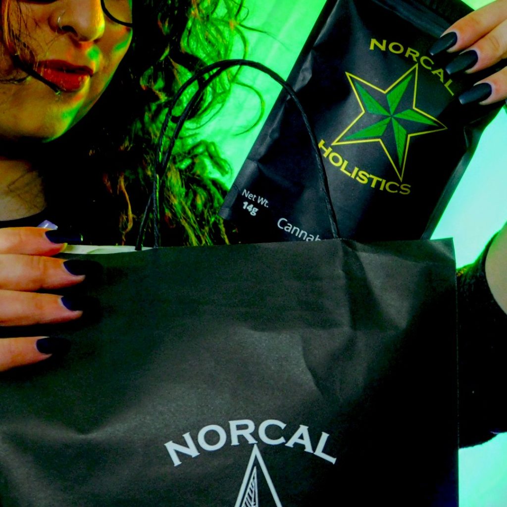Female holding Norcal Holistics bag with cannabis flower